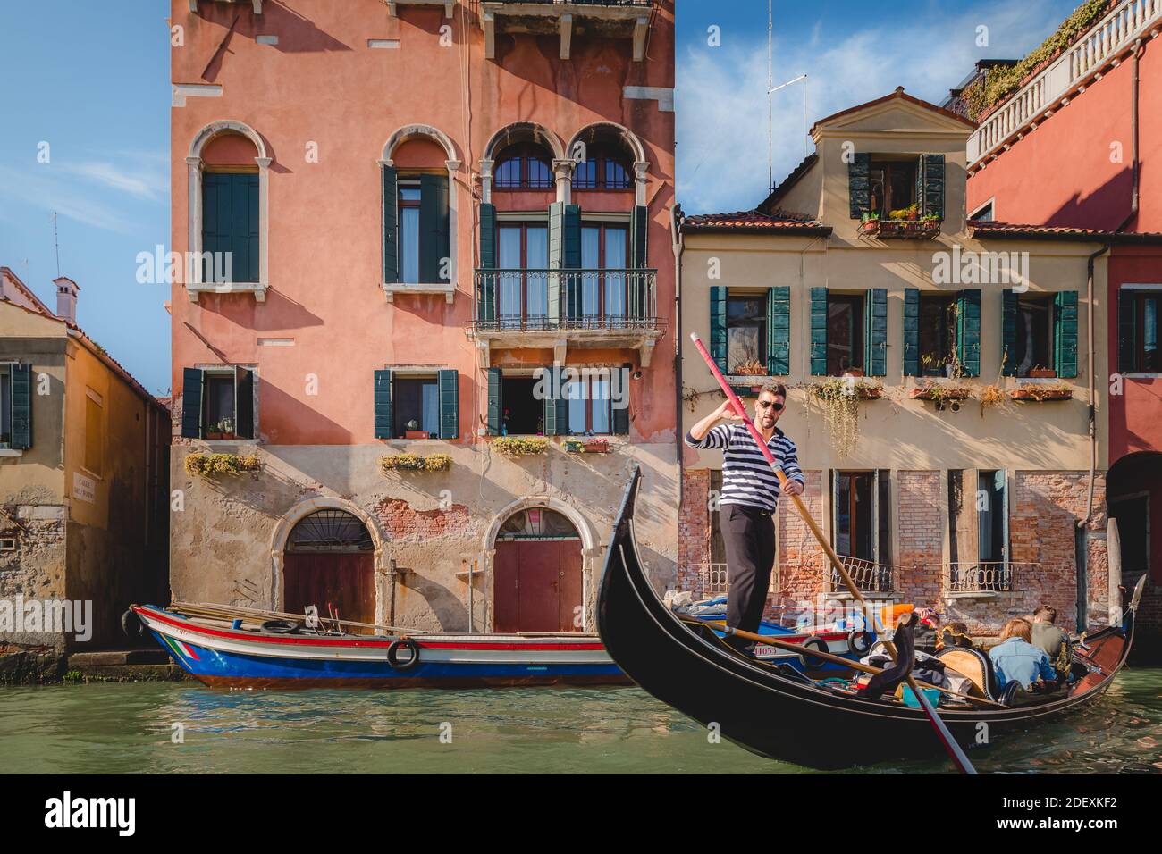 Un gondolier tire une manœuvre serrée avec les touristes à bord. Banque D'Images