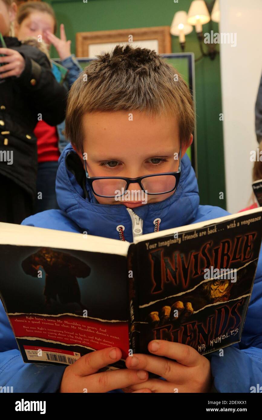 Boswell Book Festival Dumfries House, East Ayrshire, Écosse, Royaume-Uni Un jeune garçon est absorbé dans la lecture de son livre Banque D'Images