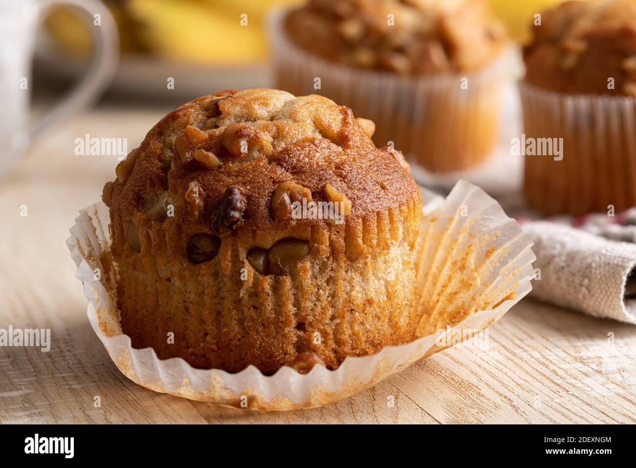 Gros plan d'un muffin aux noix de banane avec des bananes et des muffins en arrière-plan Banque D'Images