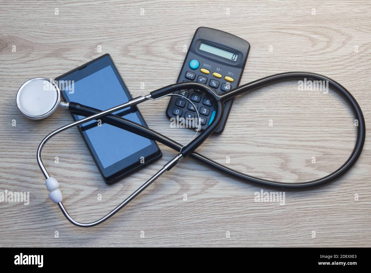 Stéthoscope noir, téléphone portable et calculatrice pour les frais de santé Banque D'Images