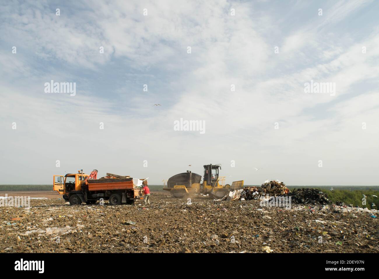 Tri des déchets dans la décharge de la grande ville. Beaucoup de déchets. Chariot avec manipulateur hydraulique manuel. Tracteur jaune. Banque D'Images