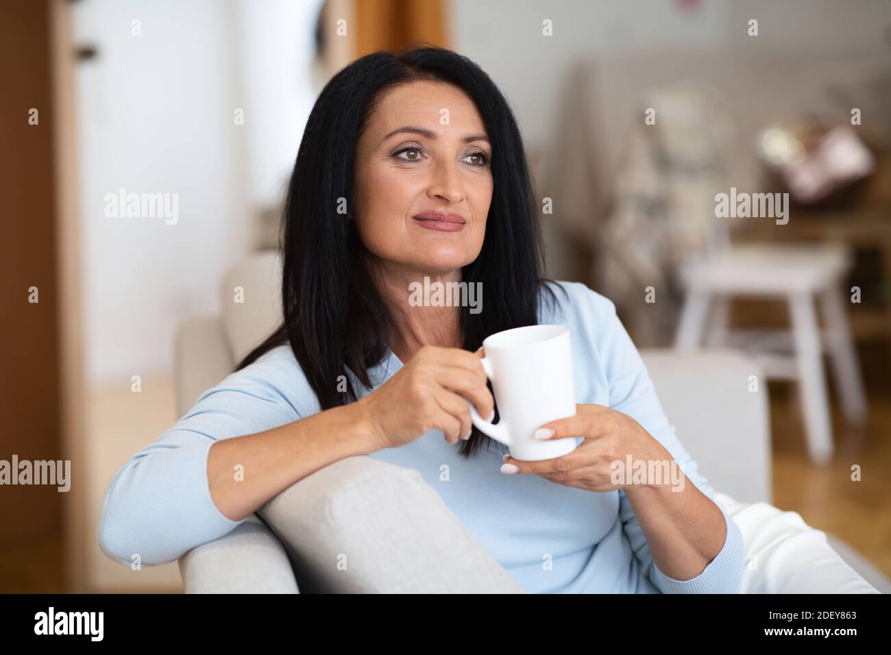 Portrait d'une femme mûre souriante qui boit du café chaud Banque D'Images