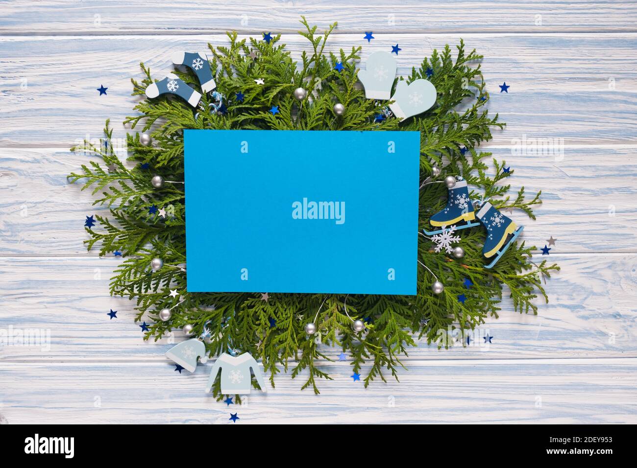 Carte de Noël vide et branches de sapin sur fond bleu en bois. Maquette pour les fêtes de fin d'année. Espace pour le texte. Banque D'Images
