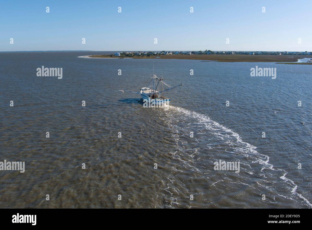 Un bateau à crevettes tire des filets de la côte de la Caroline du Sud dans cette vue aérienne. Banque D'Images