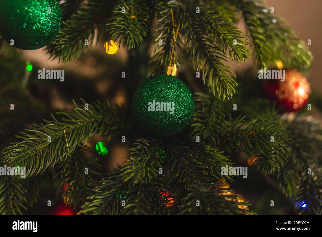 Magnifique sapin de Noël avec jouet vert sur les branches gros plan