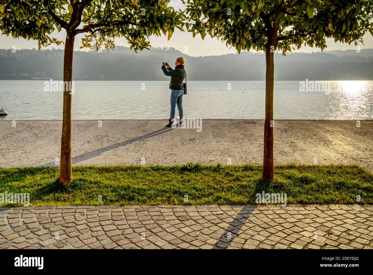 Une femme de race blanche d'âge moyen qui a tiré un selfie debout Sur la rive du lac de Garde dans la ville de Salo En Italie à l'automne 2020 Banque D'Images