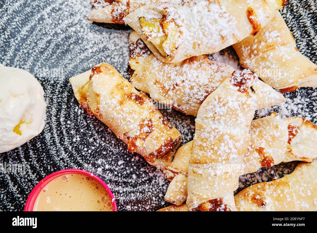 Vue de dessus de la poire cuite enveloppée dans une pâtisserie à la cannelle servi avec de la crème glacée Banque D'Images