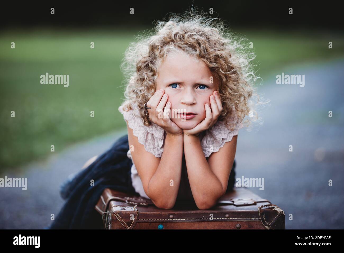 portrait d'une belle fille blonde avec boucles et mains sur son visage Banque D'Images portrait d'une belle fille blonde avec boucles et mains sur son visage Banque D'Images