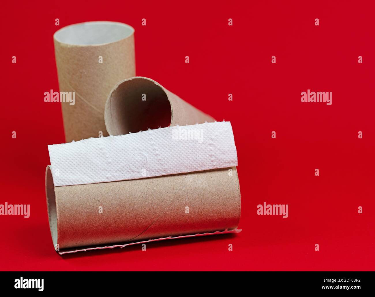 Rouleaux de papier toilette usagés sur fond rouge Banque D'Images