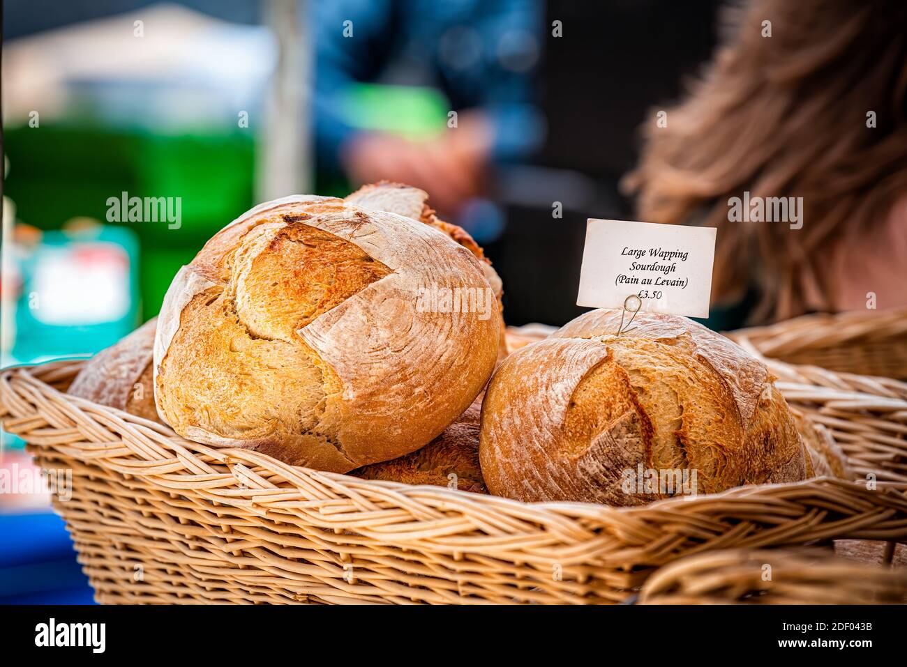 Exposition au détail au stand boulangerie de stand de grande pâte à pain wapping français, pain au Levain au Chelsea marché des producteurs alimentaires en panier en bois d'osier avec pri Banque D'Images