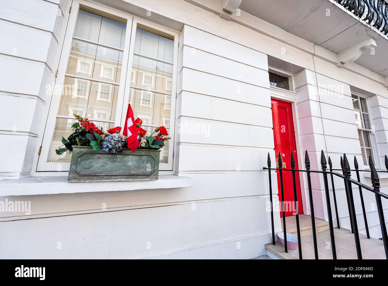 Ediwardian style géorgien architecture maison de ville résidentielle bâtiment pour appartement avec entrée de porte rouge et fleurs en pot à Londres, United Kin Banque D'Images