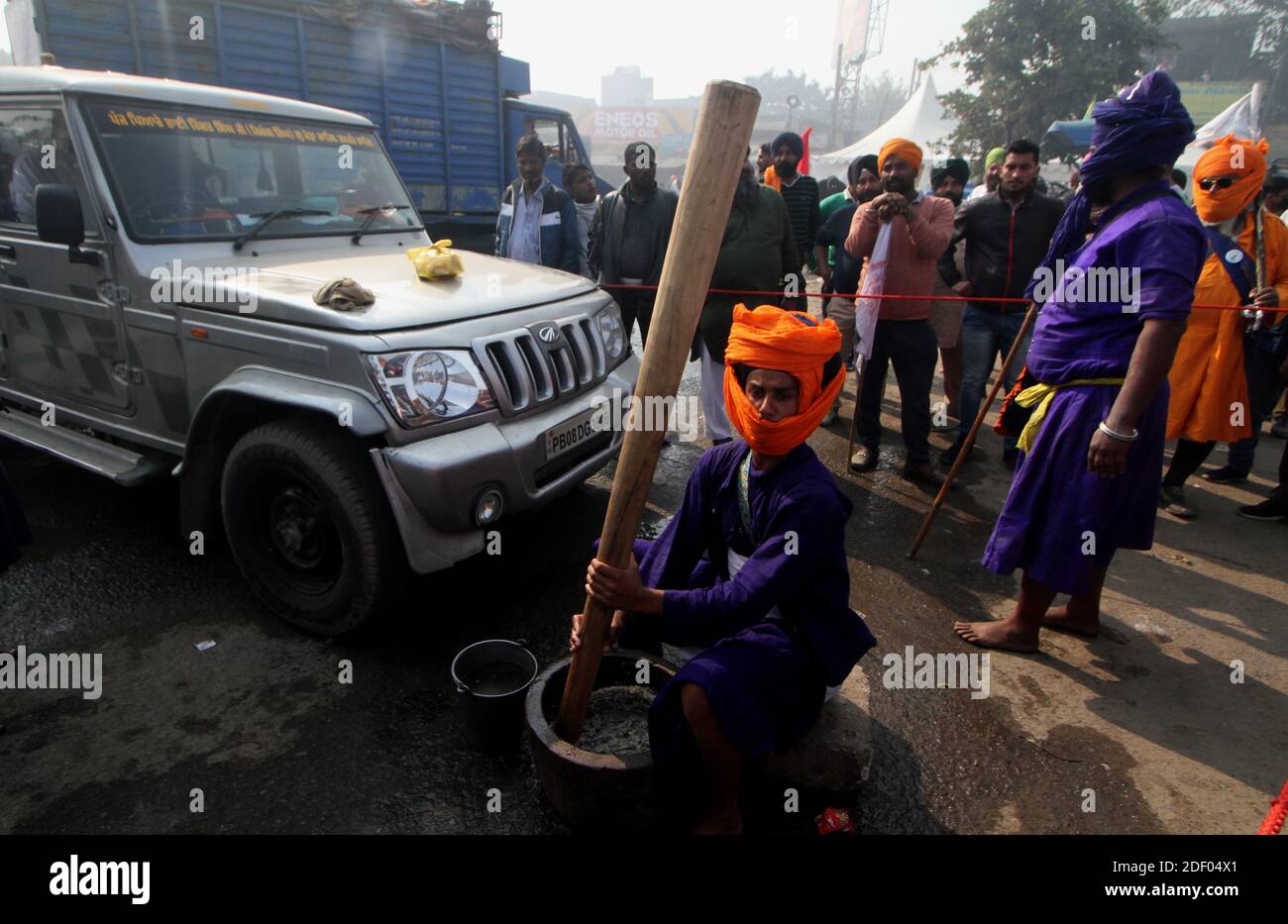 Un Nihang ou un Akali (guerrier Sikh armé) préparent de la nourriture à son co-Nihang pendant la manifestation.des milliers d'agriculteurs de divers États se sont rassemblés à la frontière de Singhu (frontière Delhi-Haryana) pour protester contre les nouvelles lois agricoles qu'ils affirment porter gravement atteinte à leurs revenus, selon le syndicat des agriculteurs. Les agriculteurs ont également demandé la définition légale de la MSP (prix de soutien minimum) et ont appelé le gouvernement central à la retirer. Banque D'Images