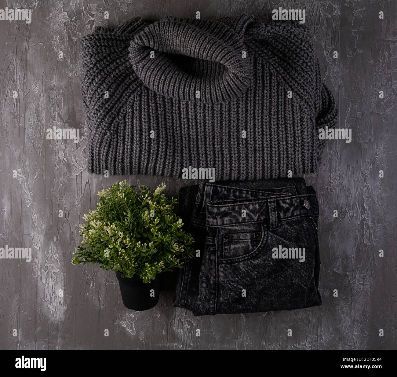 Vêtements de mode automne et hiver. Chandail en laine gris, jeans. Photographie en vue de dessus, composition de la pose à plat. Arrière-plan des vêtements monochromes d'automne Banque D'Images