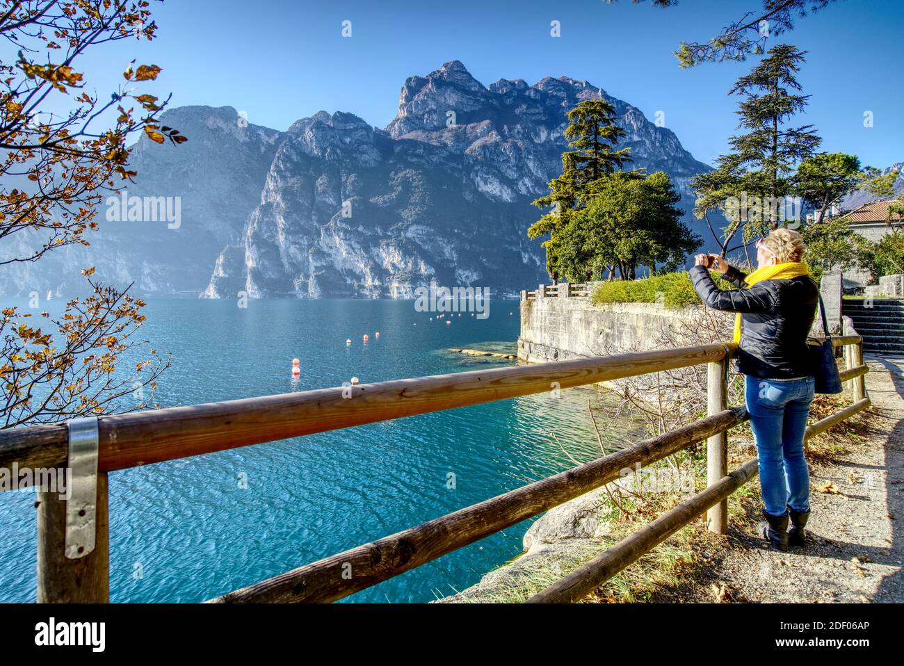 Une femme d'âge moyen de race blanche qui photographie une photo debout Sur la rive du lac de Garde dans la ville de Salo En Italie à l'automne 2020 Banque D'Images