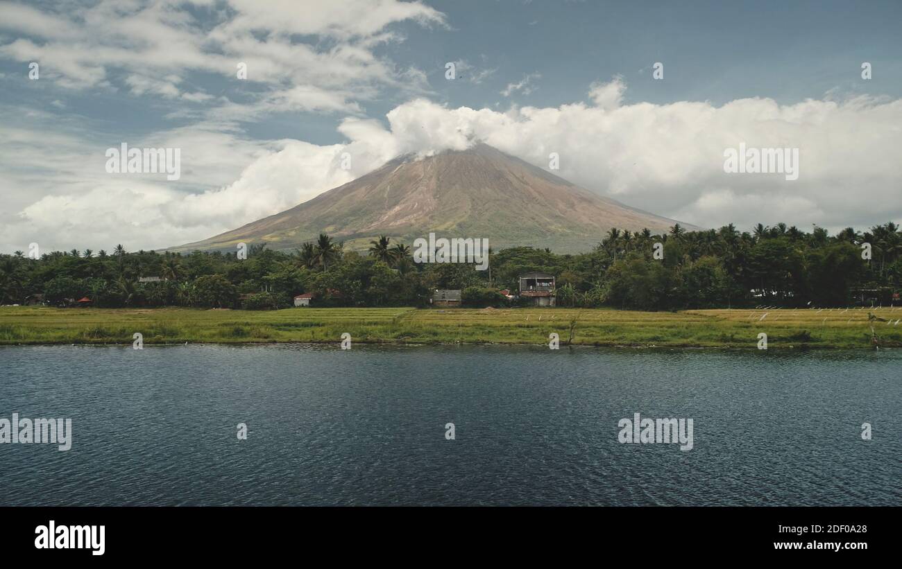 Éruption volcanique à l'antenne verte de bord de lac. Philippines province de campagne de la ville de Legazpi, à proximité de prairies verdoyantes, de palmiers. Petits cottages dans la forêt tropicale. Tropical personne nature paysage tir de drone Banque D'Images