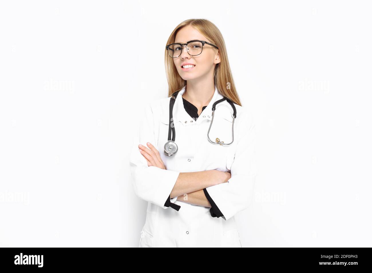 Une jeune fille en lunettes, avec un stéthoscope autour de son cou, souriant avec joie, sur fond blanc. Concept, hôpital, santé Banque D'Images