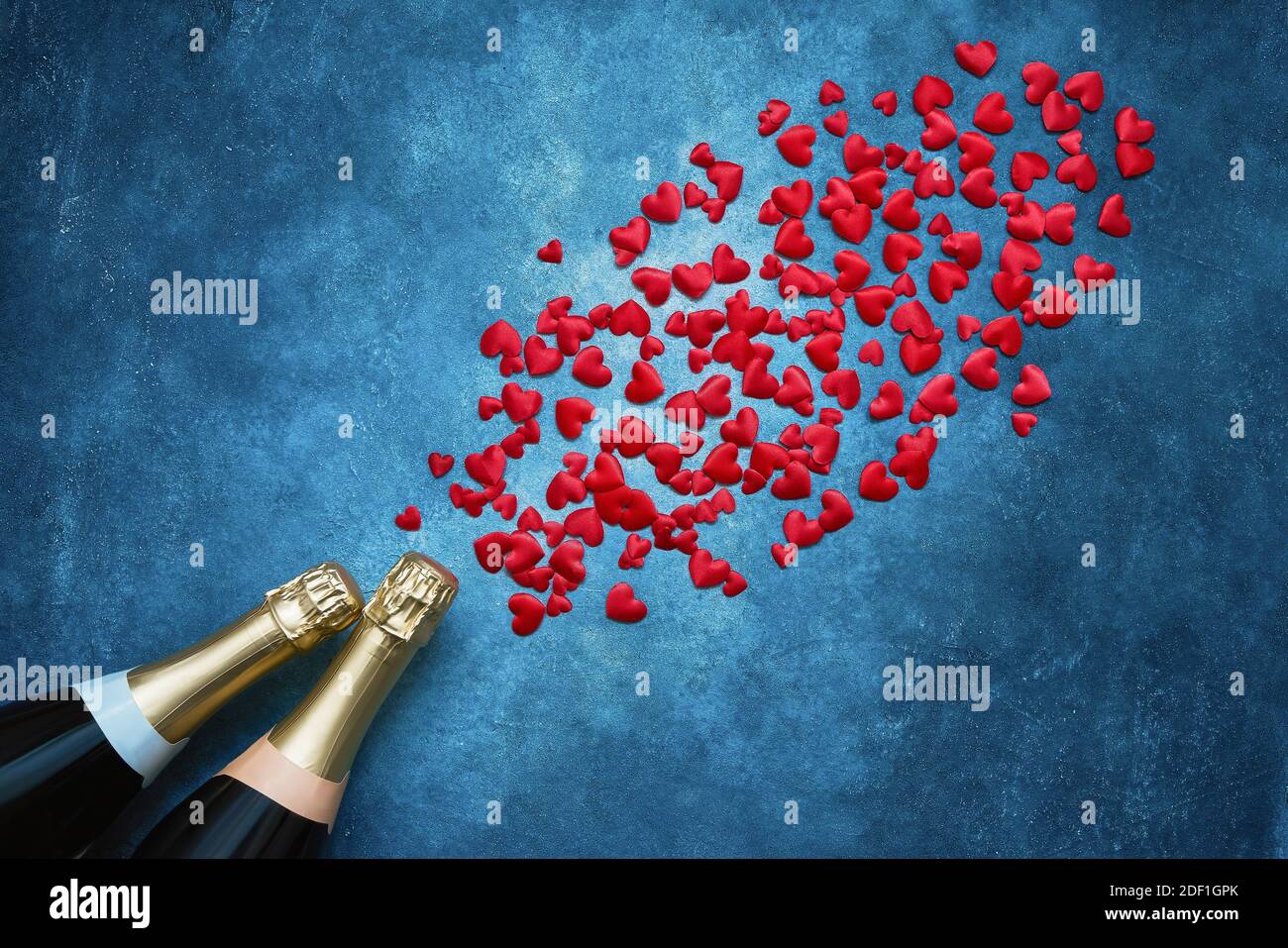 Contexte de la Saint-Valentin. Deux bouteilles de champagne à cœur rouge sur fond bleu. Espace de copie, vue de dessus. Célébration de la Saint-Valentin Banque D'Images