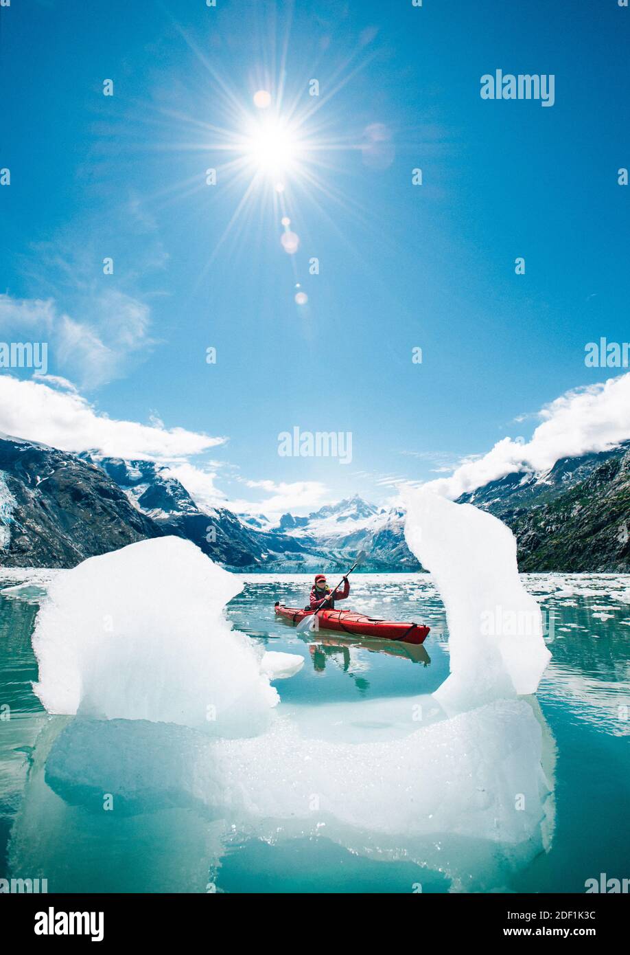 Femme en kayak dans le parc national de Glacier Bay avec iceberg premier plan Banque D'Images