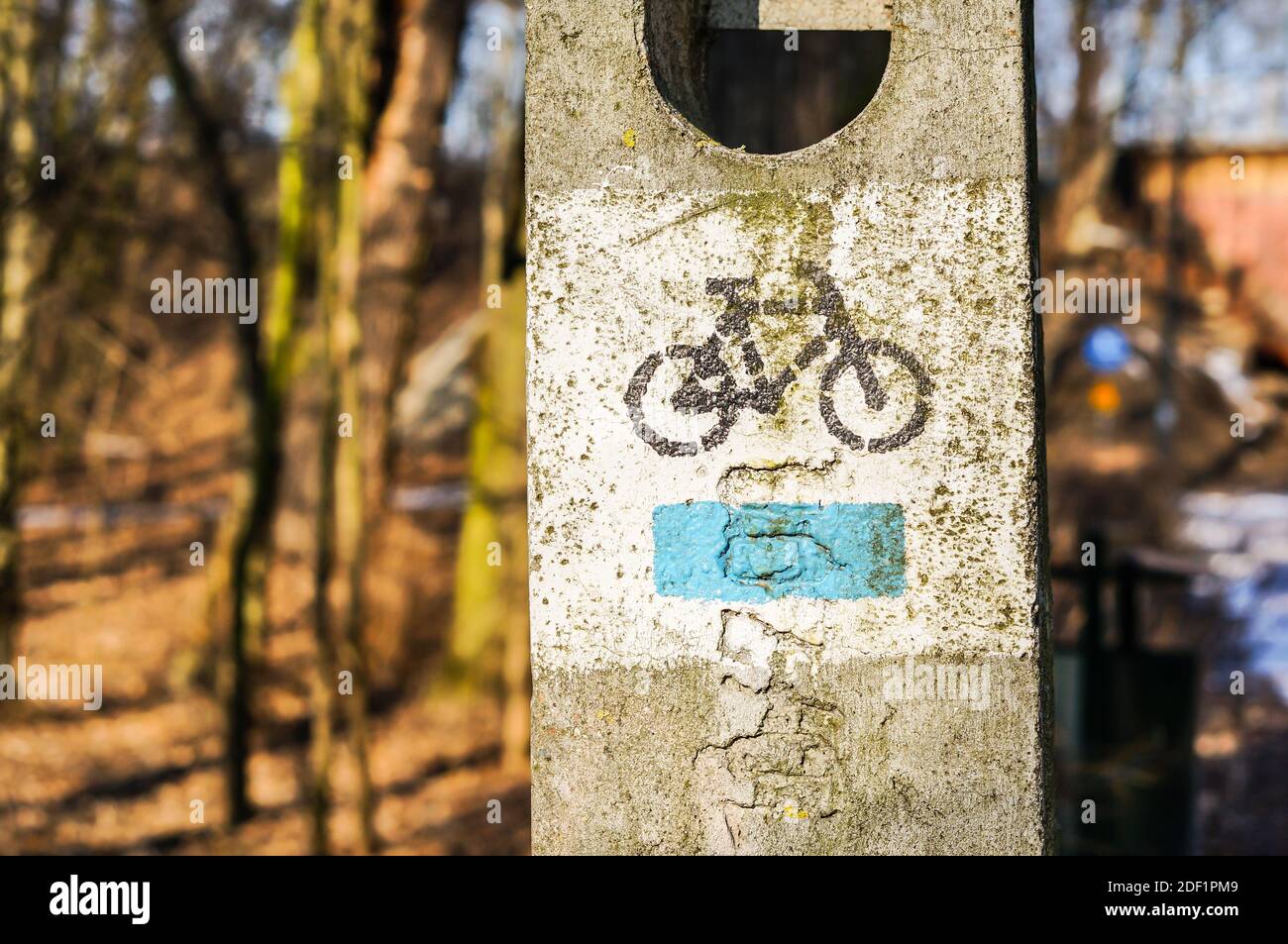 Gros plan d'un panneau de vélo pulvérisé sur un poteau en béton Banque D'Images