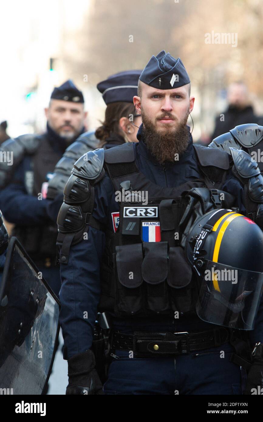 Les forces de police ( CRS ) avec un drapeau français sur l'uniforme lors  d'une manifestation organisée par plusieurs syndicats de travailleurs  représentatifs le 29 janvier 2020 à Paris, France, contre les