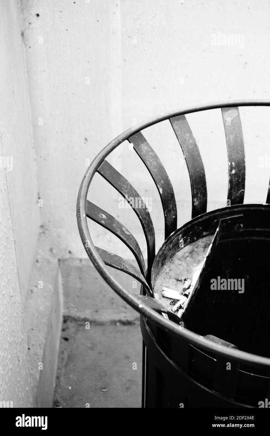 Un cliché vertical d'une poubelle métallique circulaire un bâtiment Banque D'Images
