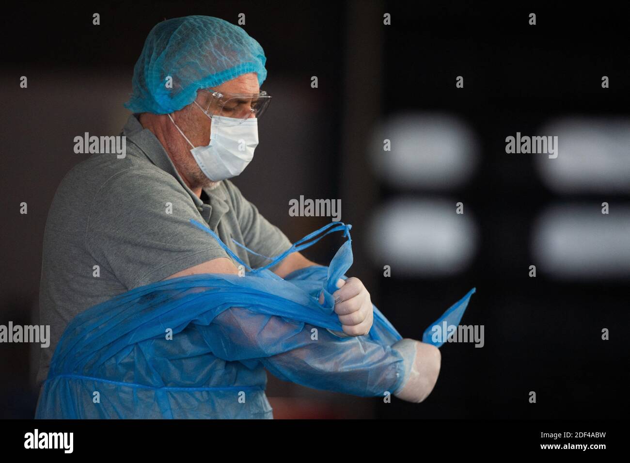 Les ambulanciers paramédicaux portant un masque de protection et une combinaison corporelle prennent le pas sur les protections utilisées après l'administration d'une personne infectée à l'hôpital de Tenon le 28 mars 2020 à Paris, alors que le pays est sous confinement pour arrêter la propagation de la pandémie Covid-19 causée par le nouveau coronavirus. Photo de Raphael Lafargue/ABACAPRESS.COM Banque D'Images