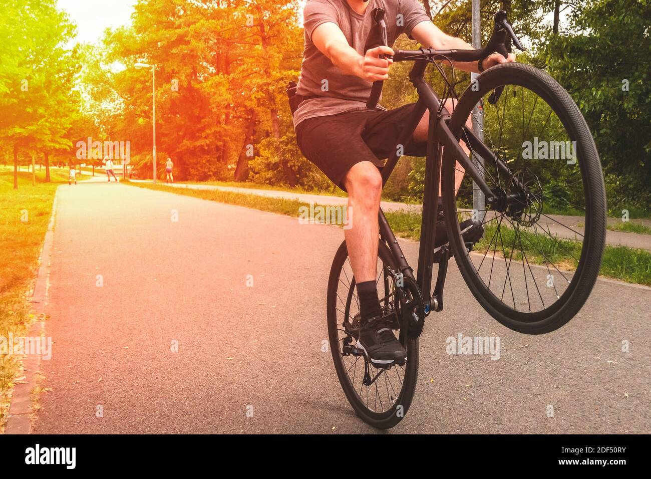 Homme en vélo sur le chemin. Faites du vélo sur la roue arrière. Banque D'Images