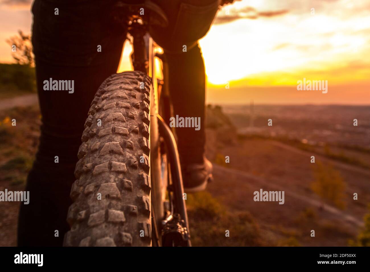 Vue arrière de la roue arrière du VTT. Gros plan sur les roues de vélo au coucher du soleil. Banque D'Images