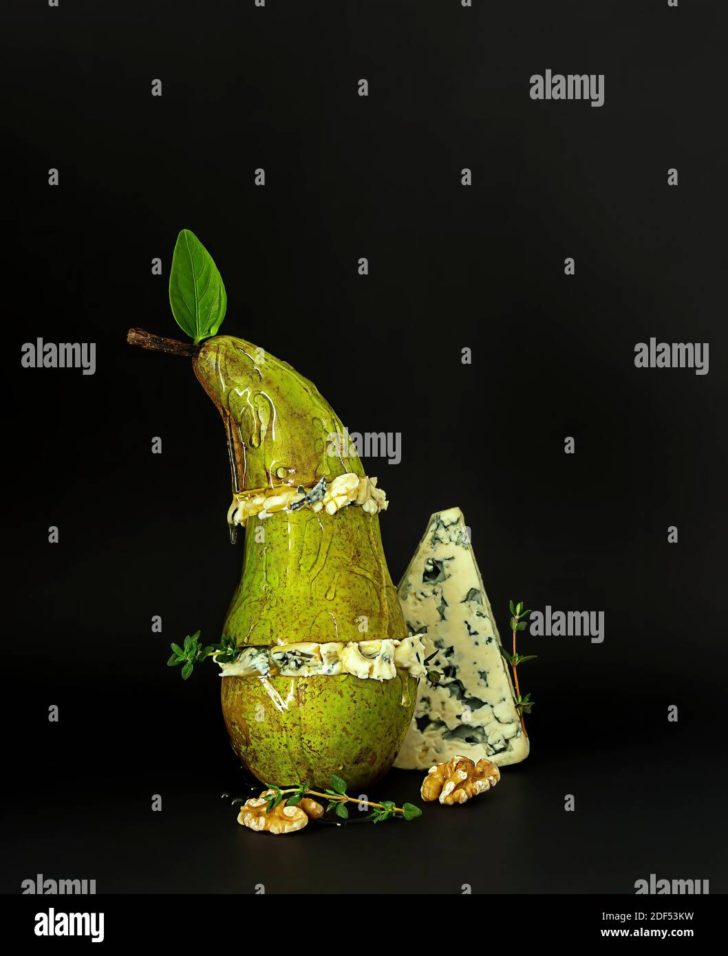 Poire et fromage bleu avec miel et noix. Concept snack gastronomique. Orientation verticale, fond noir Banque D'Images