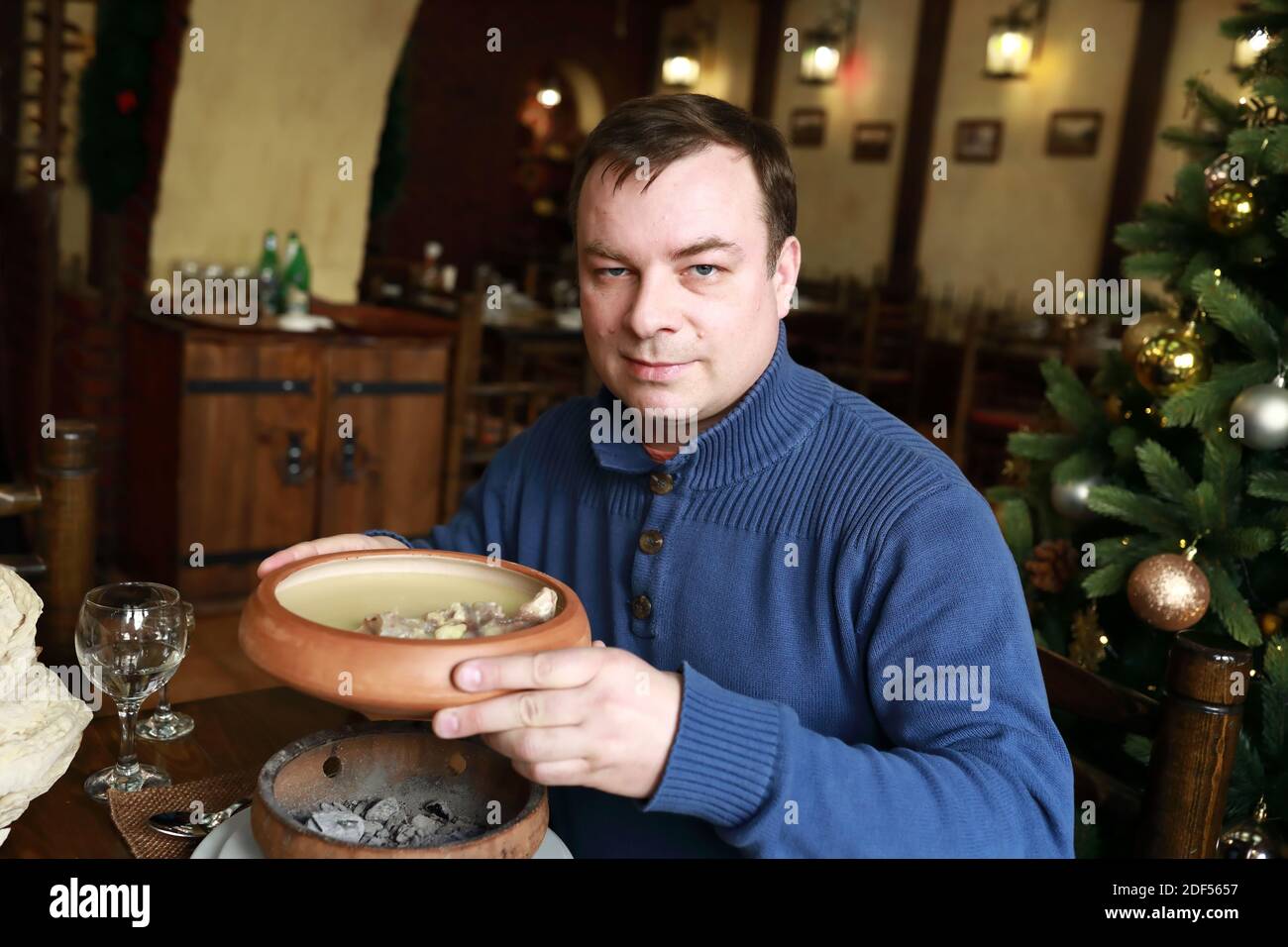Homme tenant un bol avec khash au restaurant Banque D'Images
