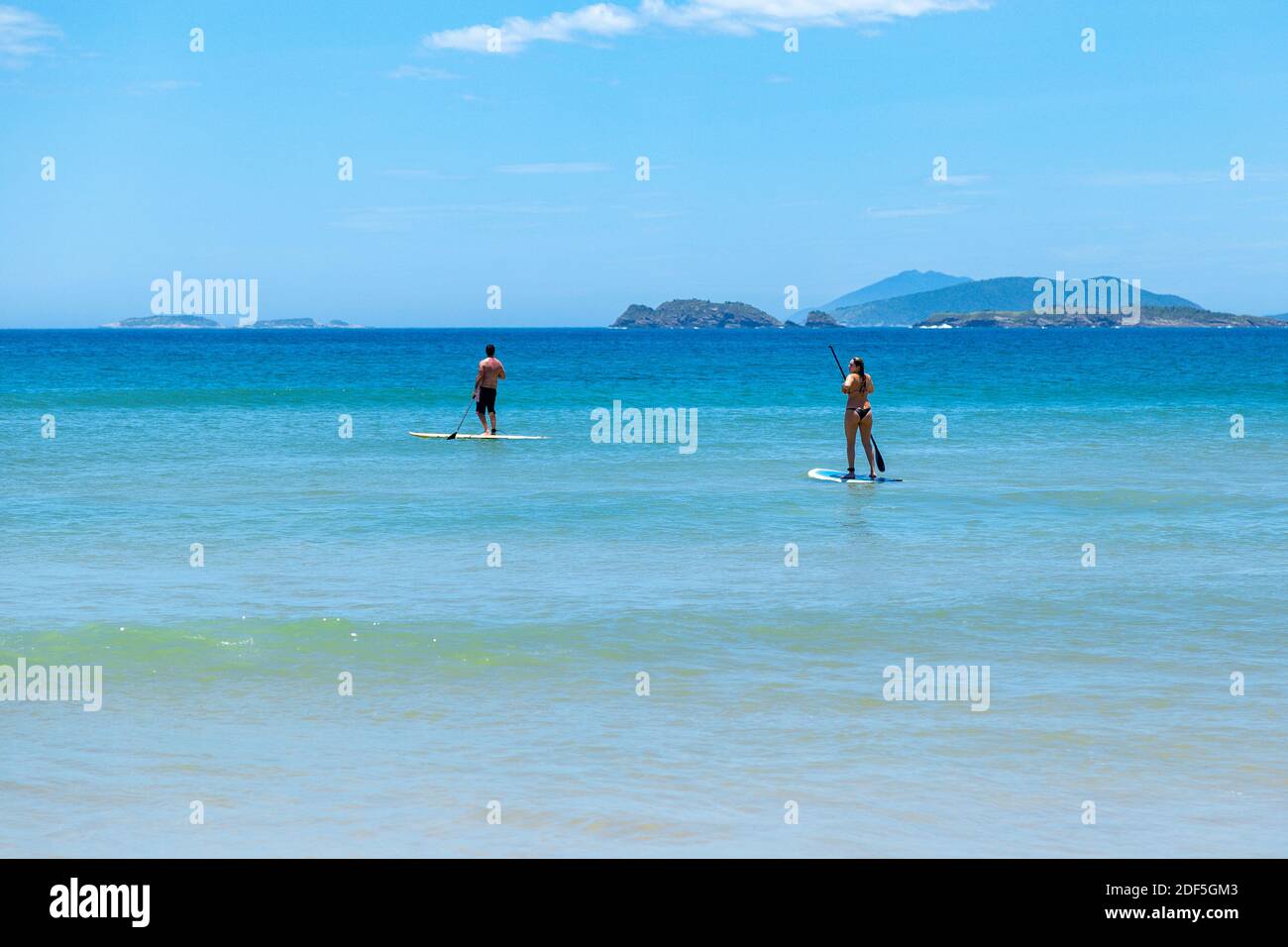 Plage de Geriba, Buzios, Rio de Janeiro, Brésil – 22 décembre 2019 : stand up paddle board (SUP) sur la côte sud de l'atlantique. Couple isolé faisant de l'aquati Banque D'Images