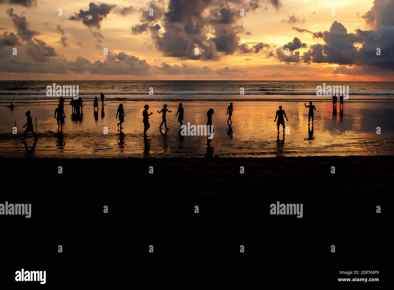 Kuta, Indonésie - 25 mars 2019 : silhouettes de gars qui jouent au football au coucher du soleil sur la plage de l'océan Banque D'Images
