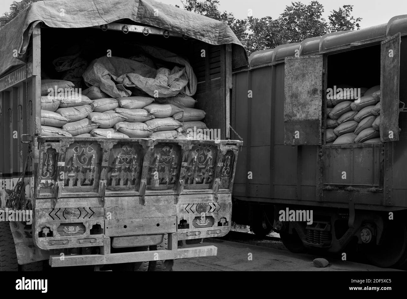 Sacs de ciment chargés manuellement du train au camion en attente de distribution ultérieure à Mathura, Uttar Pradesh, Inde. Banque D'Images