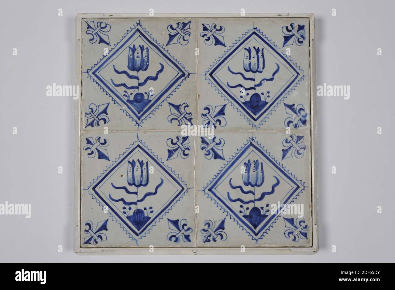 Champ de carreaux, Anonyme, première moitié du XVIIe siècle, glaçure d'étain, faïence, avec cadre : 28 x 28 x 3,5cm (280 x 280 x 35mm), carreau : 13 x 13 x 1,2 cm (130 x 130 x 12 mm), tulipe, pays-Bas du Nord, Tegelveld de quatre (deux par deux) carreaux de faïence recouverts de vernis d'étain et peints en bleu. Les tulipes sont représentées dans un carré dentelé sur les carreaux. La tuile a un motif de coin en tant que nénuphar, Date1985 Banque D'Images
