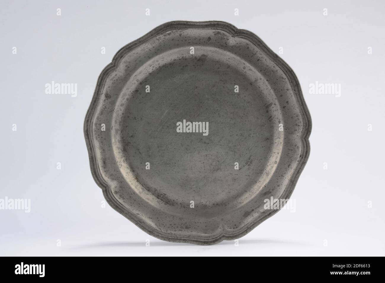 Assiette (vaisselle), Anonyme, milieu du XVIIIe siècle, fonte, général: 2.1 x 23,9 cm (21 x 239 mm), plaque plate avec rebord plat en étain moulé, bord festonné cinq fois. Chaque coque est ondulée trois fois. Une arête profilée a été appliquée trois fois autour de l'arête. Percé sur le dos: P.M.L.B .. Marqué en bas, 1951 Banque D'Images