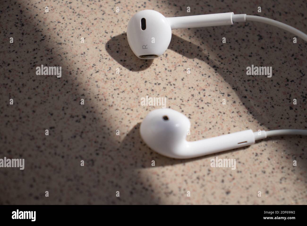 Écouteurs blancs dans la lumière du soleil, gauche et droite, écouteurs Apple Banque D'Images