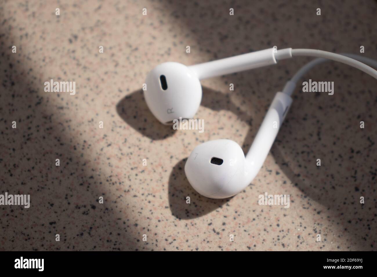 Écouteurs blancs dans la lumière du soleil, gauche et droite, écouteurs Apple Banque D'Images
