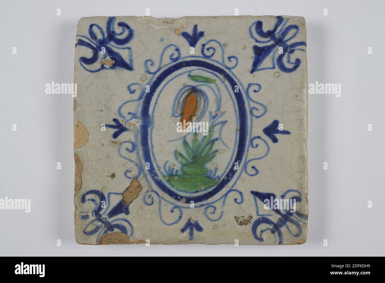 Carreau mural, Anonyme, entre 1620-1650, glaçure d'étain, faïence, général : 13 x 12.8 x 1,4cm (130 x 128 x 14mm), fleur, carreau mural en faïence recouvert de glaçure d'étain. Multicolore peint en bleu, vert et orange-brun. La tuile représente une fleur sur un sol à l'intérieur d'un ovale avec des nénuphars. La fleur a une longue tige avec quatre feuilles de chaque côté. La tuile a un motif d'angle à trois points, 1995 Banque D'Images