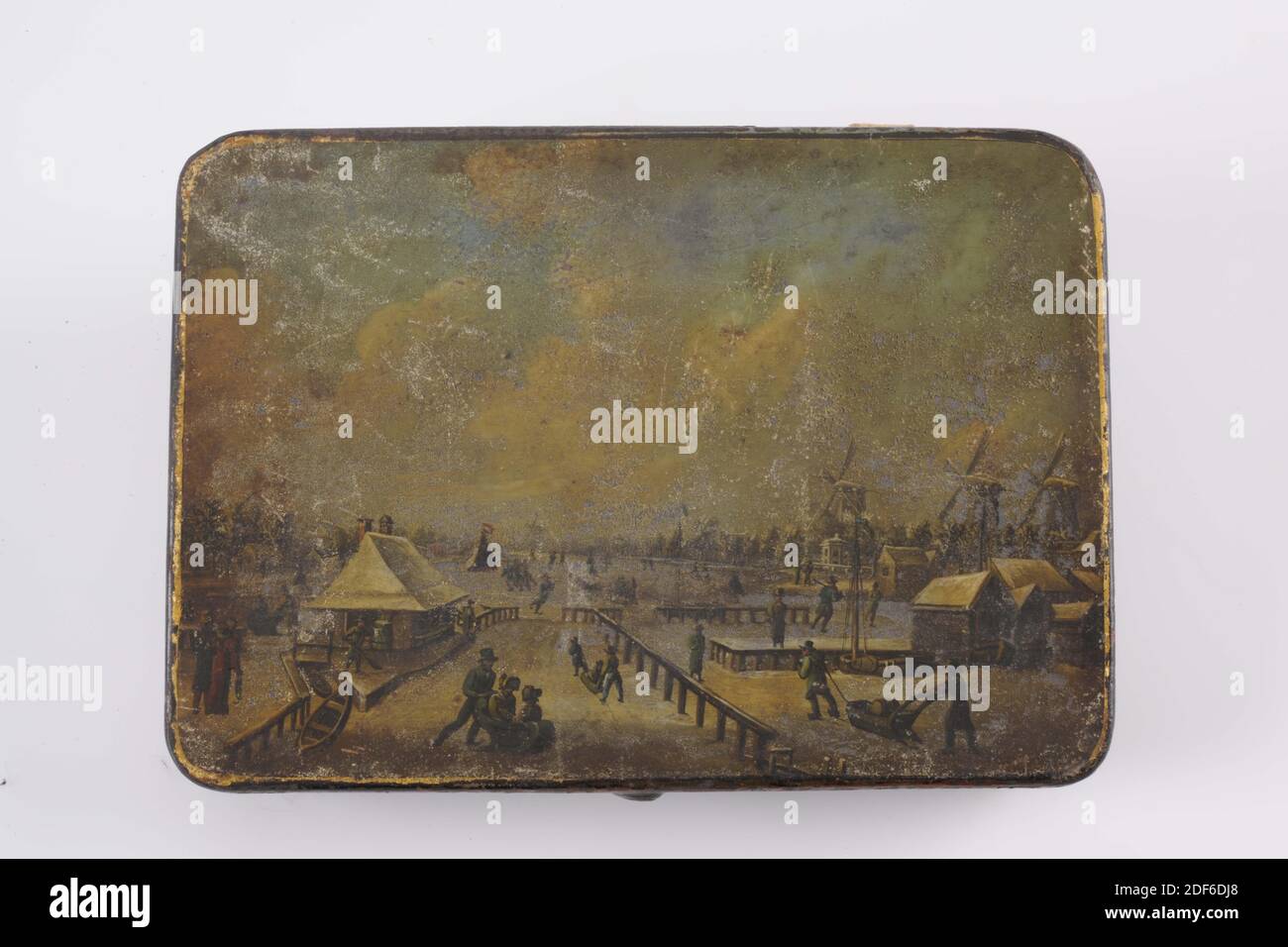 Boîte à tabac, Anonyme, première moitié 19e siècle, peint, général: 3.3 x 17.4 x 12,4cm (33 x 174 x 124mm), patins, moulin à vent, paysage d'hiver, maison, traîneau, enfant, boîte à tabac avec couvercle à charnière, d'étain peint avec l'image d'un paysage d'hiver sur le couvercle. Sur la droite se trouvent trois moulins à vent et quelques maisons. Les gens patinent en premier plan et en arrière-plan; en premier plan sont aussi des gens avec un traîneau. Une étiquette est imprimée sur la collection intérieure M. J. Van Buttingha Wichers., 1891 Banque D'Images