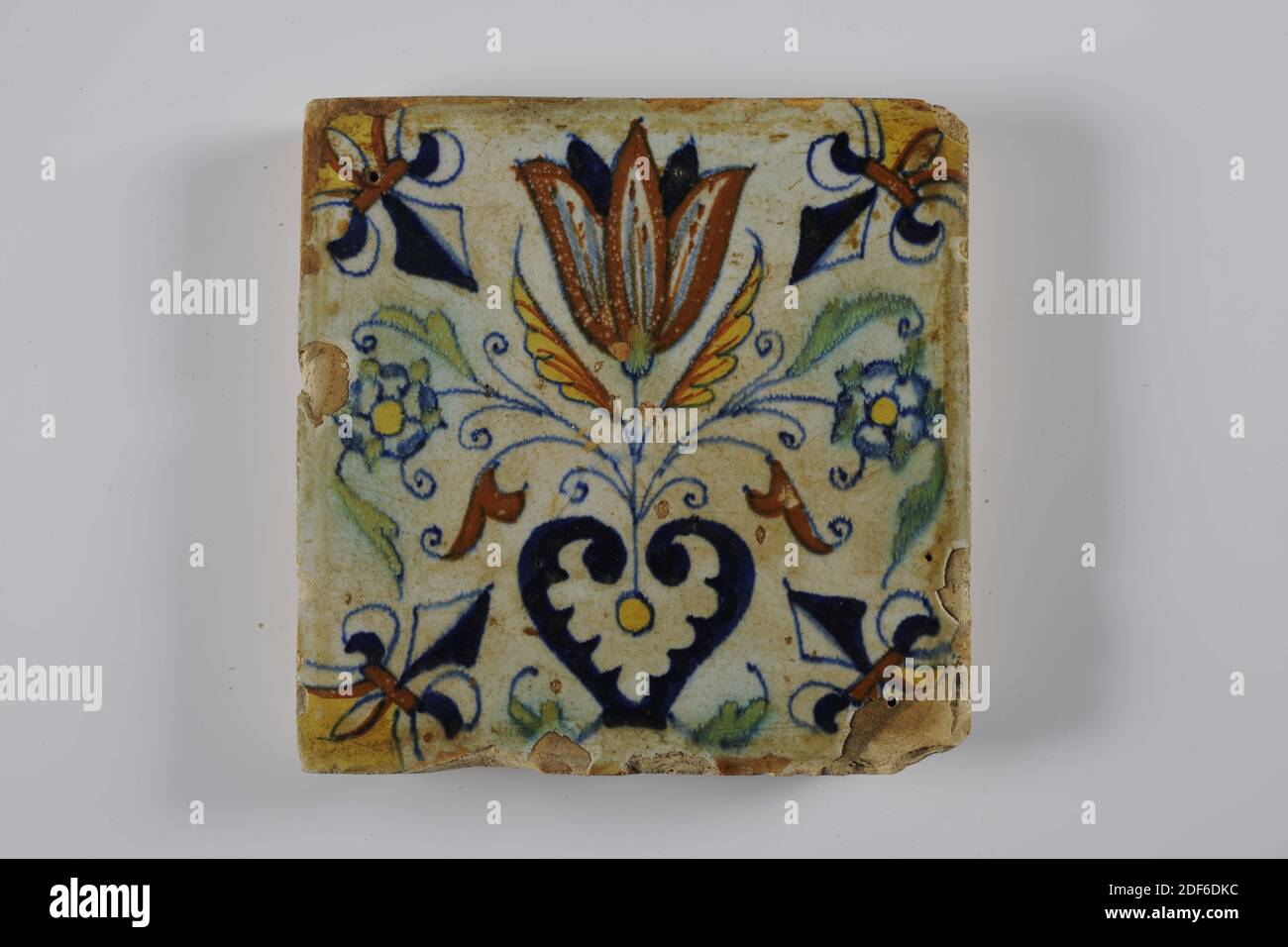 Carreau mural, Anonyme, entre 1610-1650, glaçure d'étain, faïence, général: 13.6 x 13.6 x 1.8cm (136 x 136 x 18mm), tulipe, carreau mural de faïence recouvert de glaçure d'étain. Multicolore peint en bleu, vert, jaune et brun orange. Une fleur à trois est représentée au centre sur le carreau. La fleur centrale est une tulipe. Les trois fleurs viennent d'un coeur. La tuile a un lis comme un motif de coin, 1995 Banque D'Images