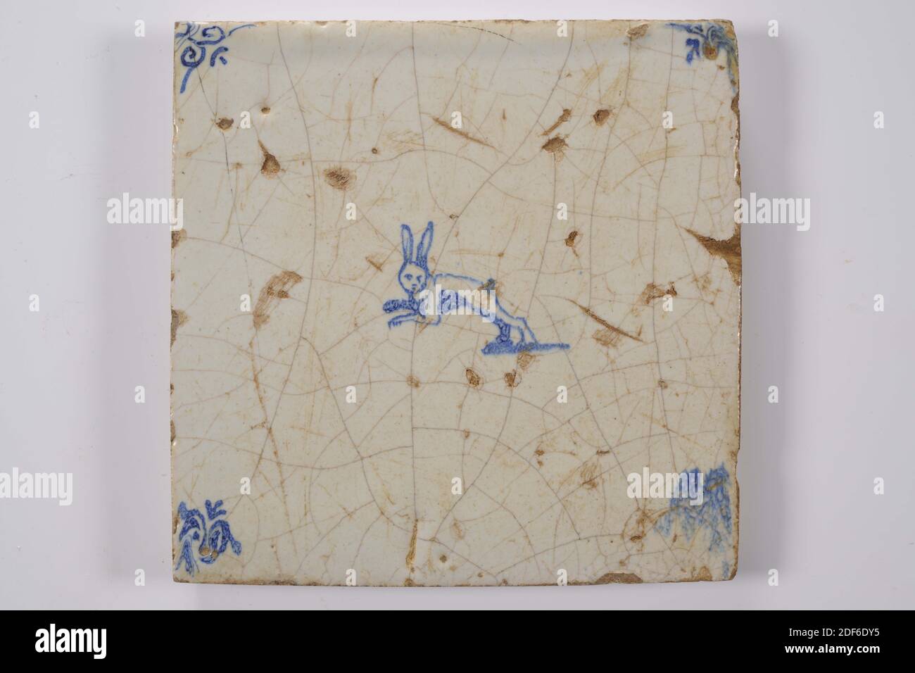 Carreau de mur, Anonyme, entre 1640-1700, glaçure d'étain, faïence, général: 13.4 x 13.5 x 1,3cm (134 x 135 x 13mm), lapin, carreau de mur de faïence recouvert de glaçure d'étain et peint en bleu. La tuile représente un lapin bondissant orienté vers la gauche. La tuile a une tête de boeuf comme un motif de coin, 1995 Banque D'Images