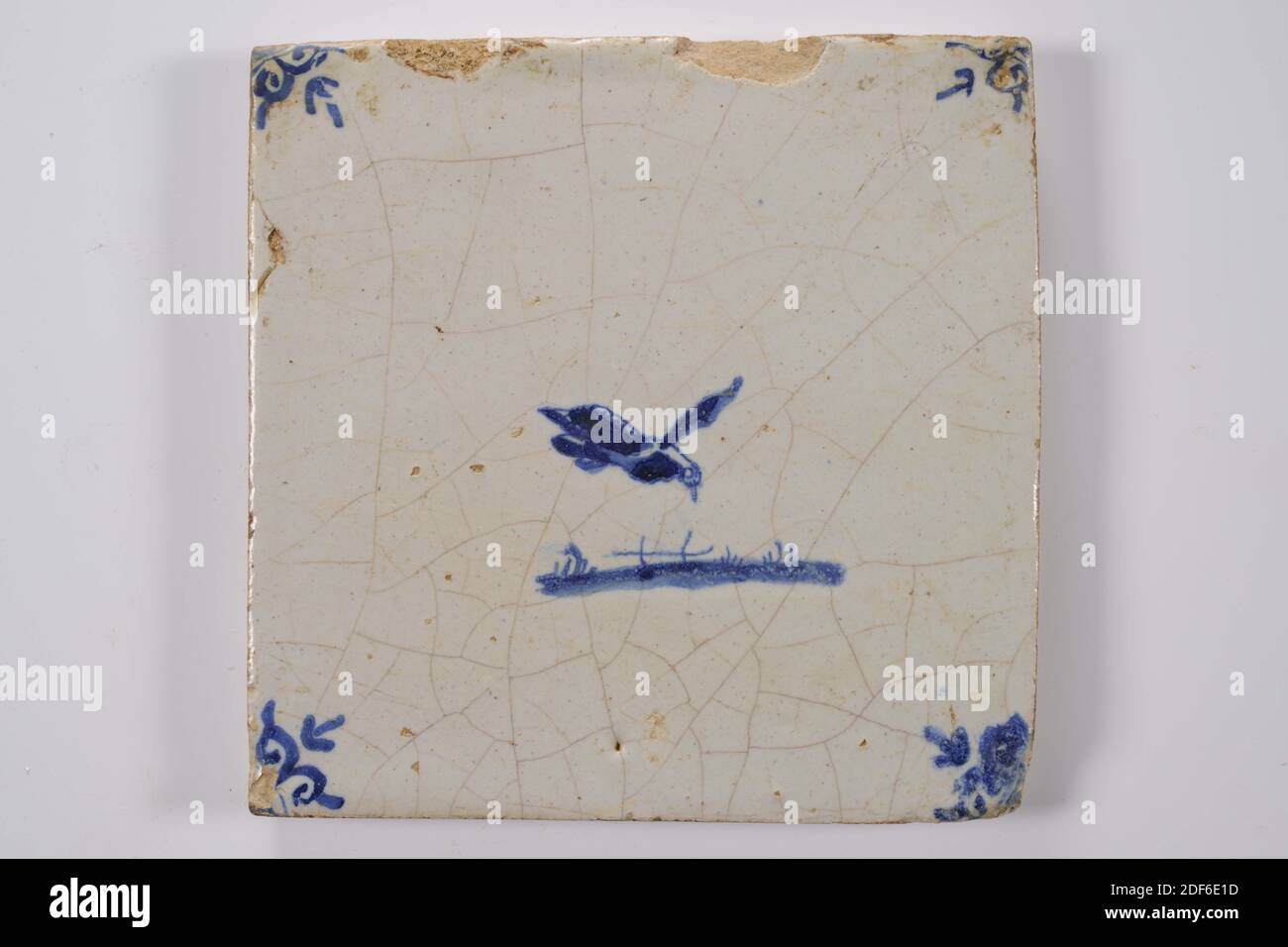 Carreau de mur, Anonyme, entre 1640-1700, glaçure d'étain, faïence, général: 13.2 x 13.4 x 1,2cm (132 x 134 x 12mm), oiseau, carreau de mur de faïence recouvert de glaçure d'étain et peint en bleu. La tuile représente un oiseau volant orienté juste au-dessus d'un sol. La tuile a une tête de boeuf comme un motif de coin, 1995 Banque D'Images