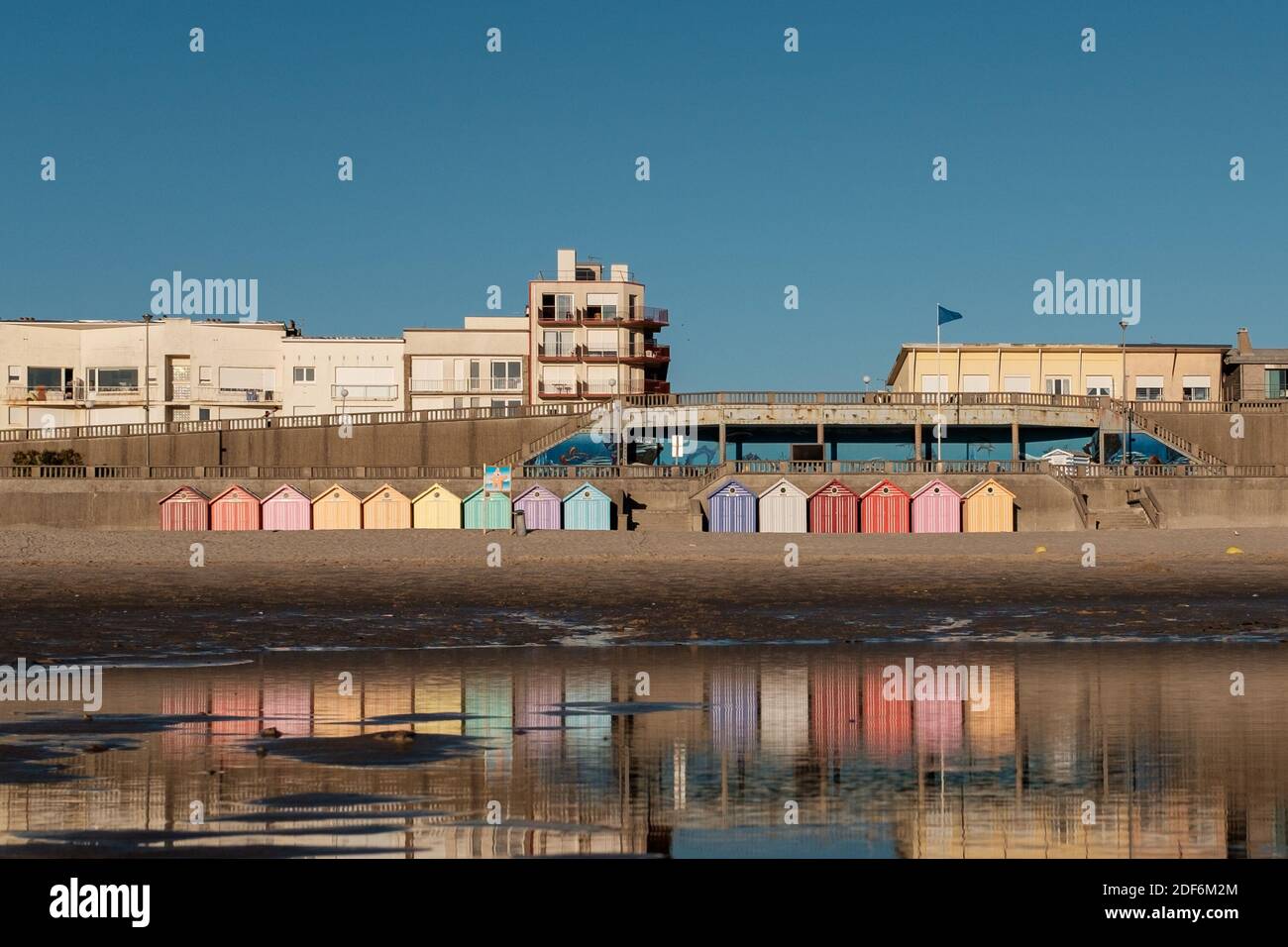 Des cabanes de plage colorées se reflètent dans les eaux des Anglais Chaîne sur Stella Plage en France Banque D'Images