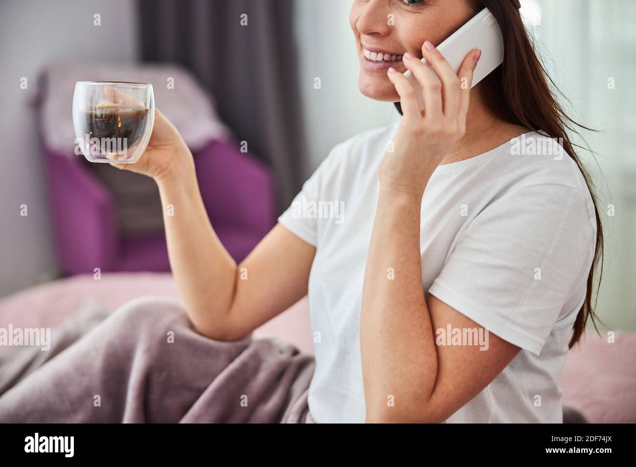 Femme adulte parlant au téléphone et prenant un café boisson Banque D'Images