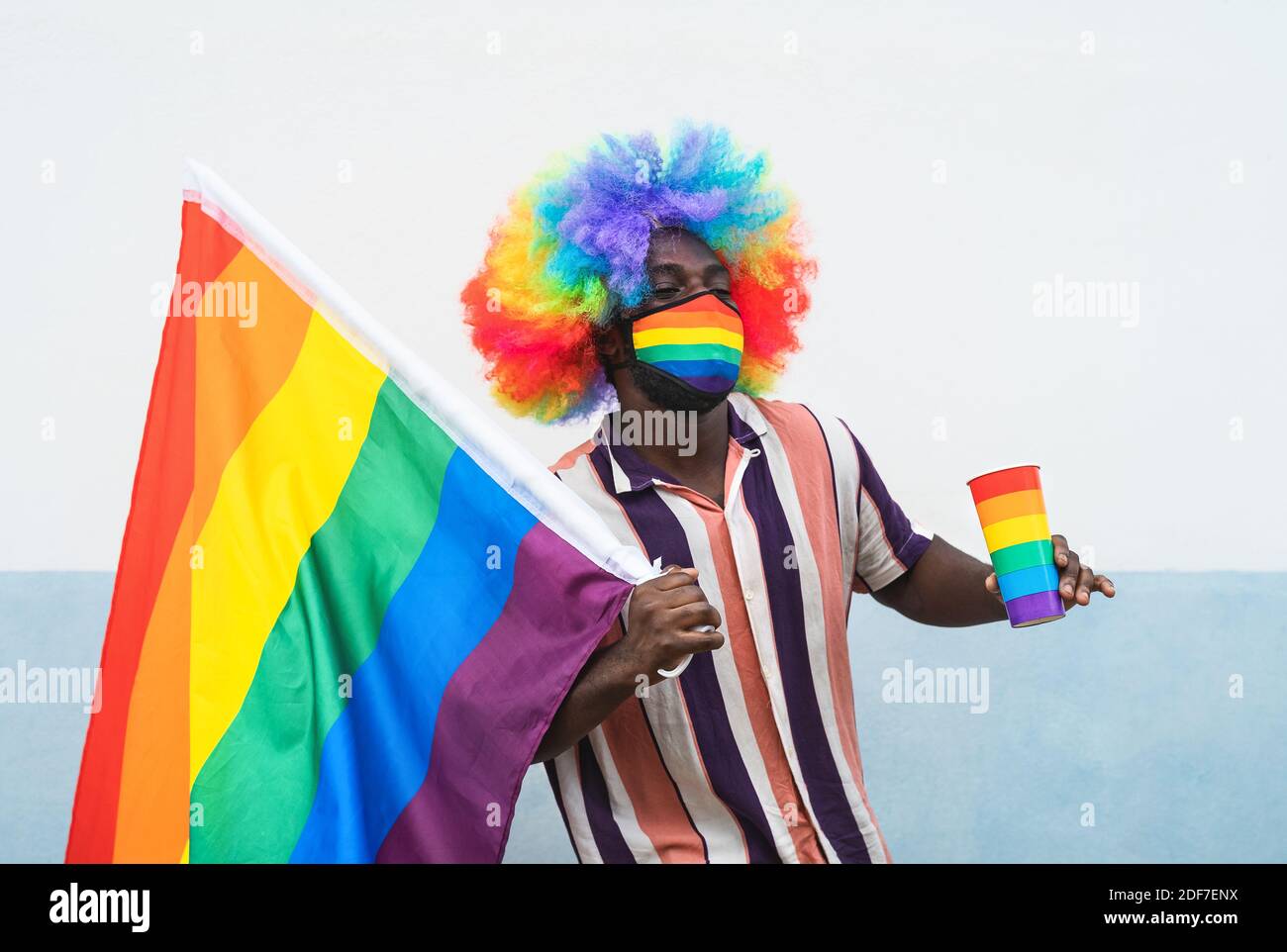 Noir gay homme ayant le plaisir de célébrer gay fierté de porter festival masque de protection du visage pour prévenir la propagation du virus corona Banque D'Images