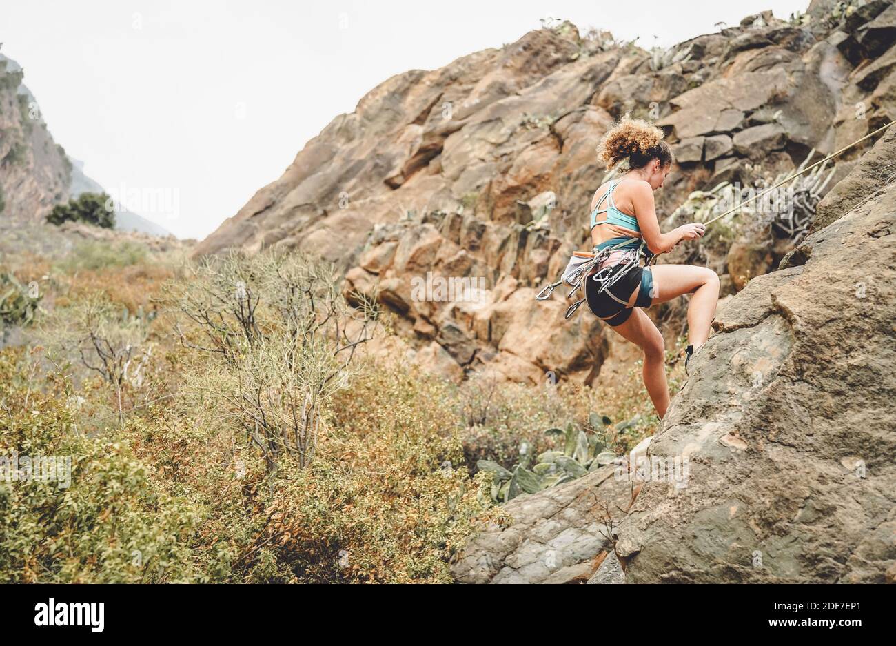 Femme sportive escalade un mur de rocher - Climber entraînement et représentation sur une montagne du canyon Banque D'Images