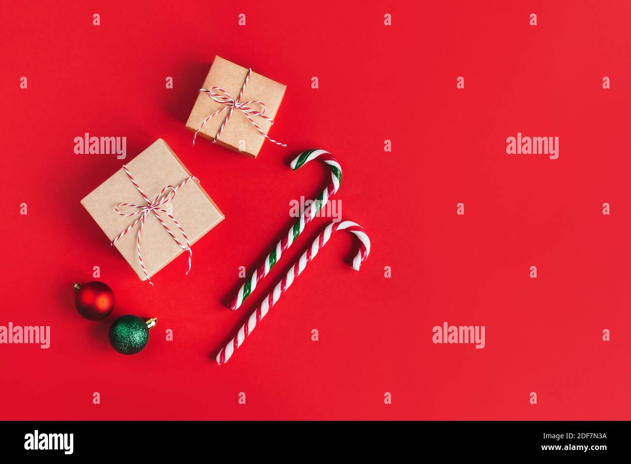 Boîtes-cadeaux avec boules christmass et Cannes de bonbons sur fond rouge. Placer pour le texte. Pose à plat. Banque D'Images