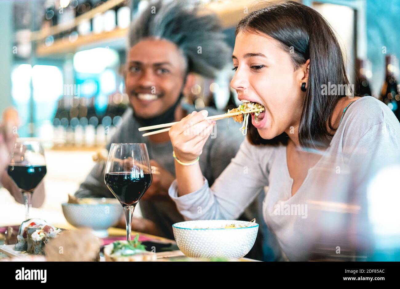 Happy couple mangeant un poke Bowl au restaurant du bar à sushis - Concept de mode de vie alimentaire avec les jeunes s'amuser ensemble à buffet à volonté Banque D'Images