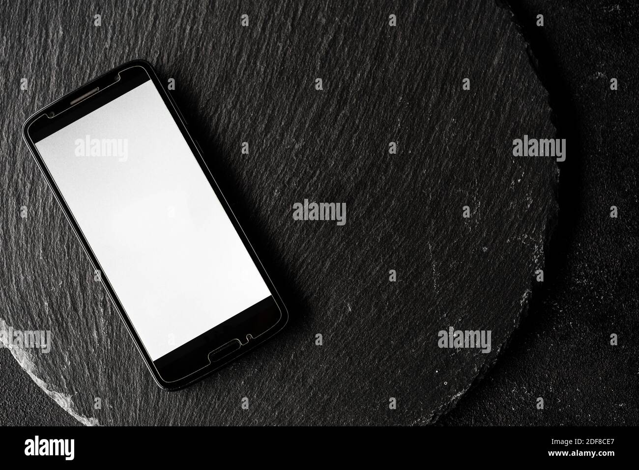 Écran vide d'un smartphone avec espace de copie sur fond noir ardoise. Banque D'Images