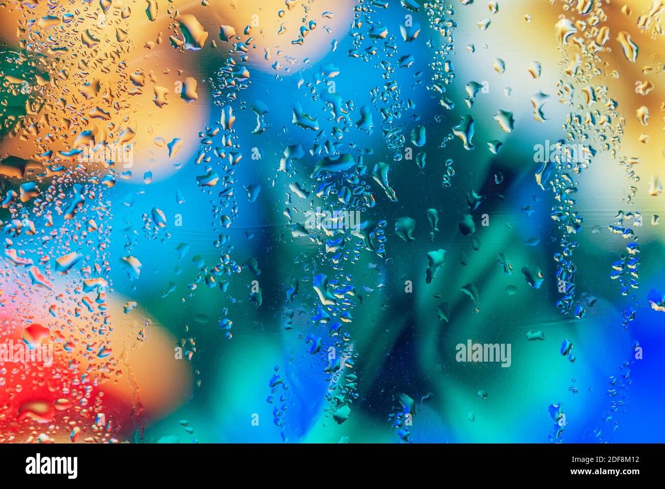 Abstrait flou coloré, pittoresque arrière-plan avec gouttes d'eau sur verre de fenêtre, tons clairs, mise au point sélective. Banque D'Images